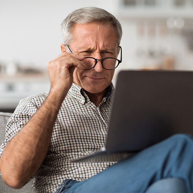 man squinting through glasses