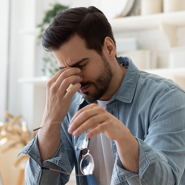 man rubbing eyes